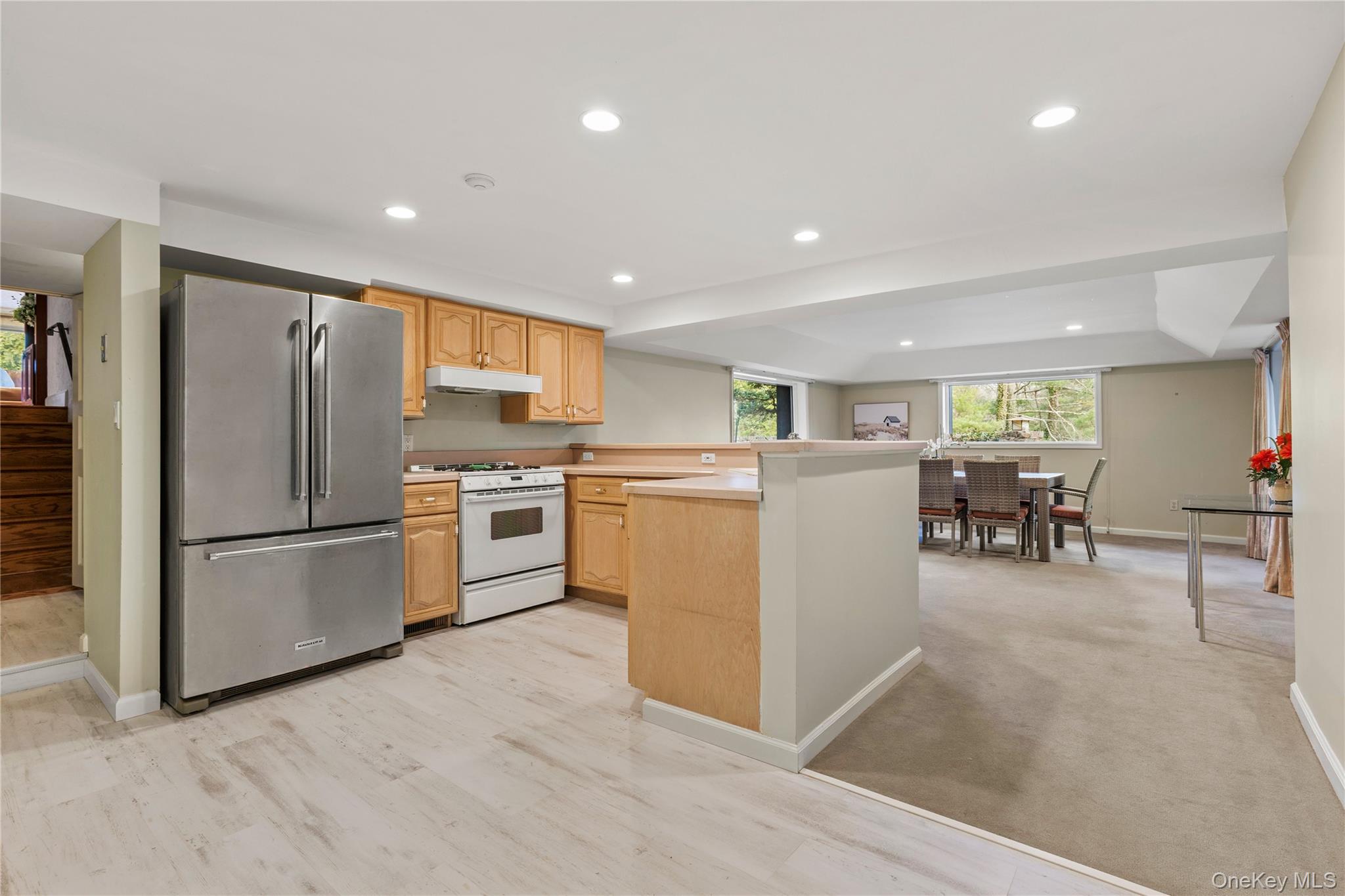 112 Woodlands Road Harrison, NY 10528 - Photo 22 of 43 a kitchen with a refrigerator a stove top oven a sink a dining table and chairs
