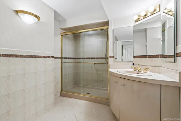 a bathroom with a shower sink and mirror