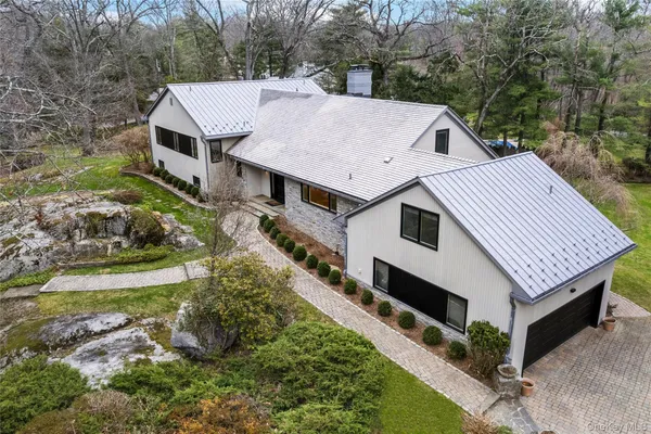 a aerial view of a house with a yard table and chairs
