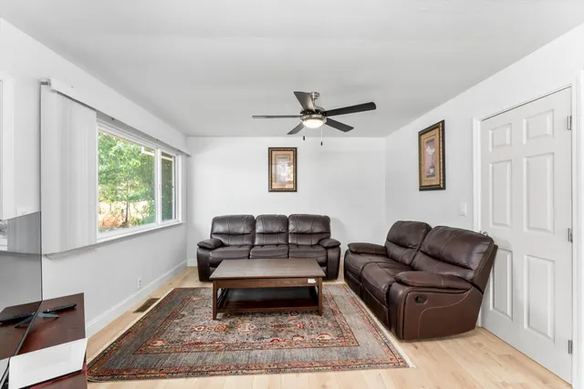a living room with furniture a flat screen tv and a table