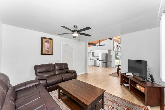 a living room with furniture a flat screen tv and a large window
