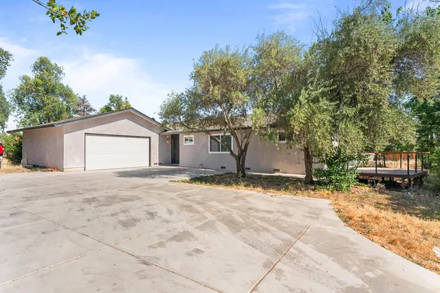 a view of a house with a backyard and a tree