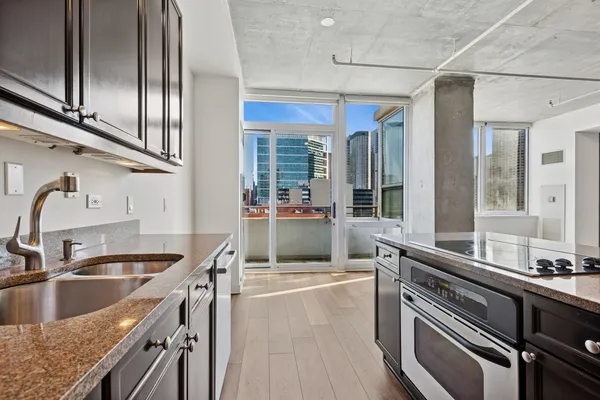 a kitchen with granite countertop a sink and a refrigerator