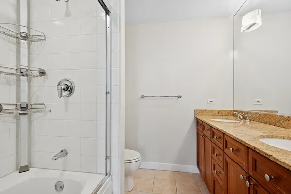 a bathroom with a granite countertop sink a toilet and shower