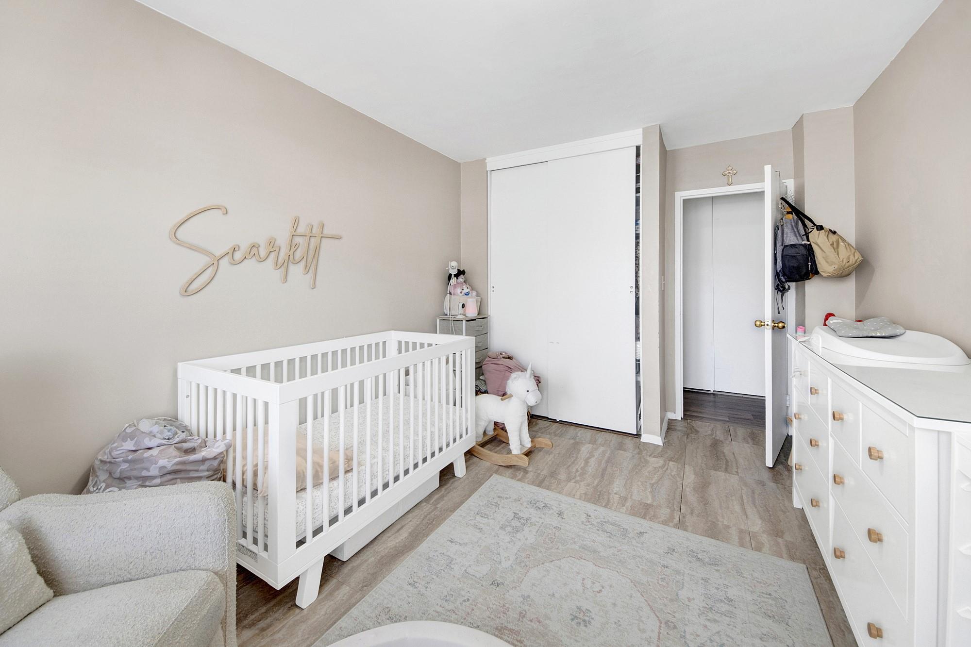 3130 Irwin Avenue, Unit 2C Bronx, NY 10463 - Photo 19 of 30 Bedroom with wood finished LVP floors, a crib, and a closet