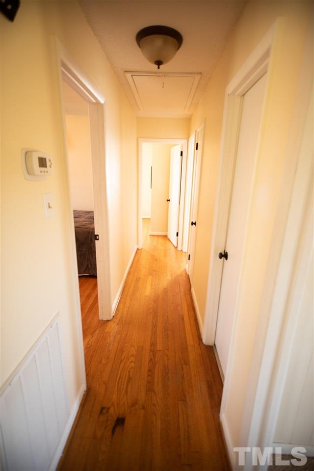 3029 Peebles Road Raleigh, NC 27616 - Photo 9 of 28 a view of a hallway with wooden floor and a cabinet