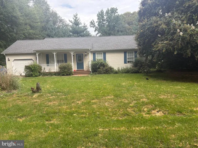 a front view of a house with a garden and yard
