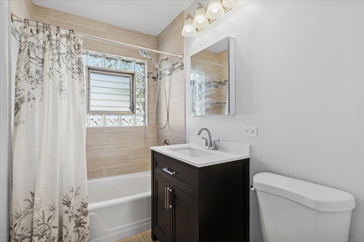 8846 North Ozanam Avenue Niles, IL 60714 - Photo 11 of 24 a bathroom with a sink toilet vanity and bathtub