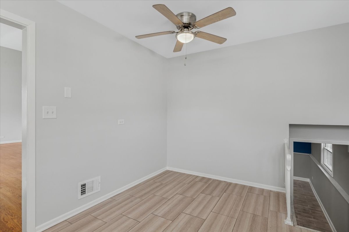 8846 North Ozanam Avenue Niles, IL 60714 - Photo 14 of 24 an empty room with a window and a ceiling fan