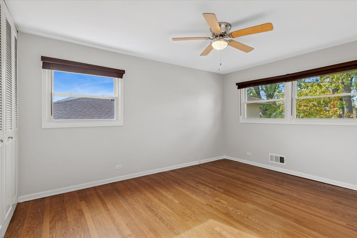 8846 North Ozanam Avenue Niles, IL 60714 - Photo 7 of 24 wooden floor in an empty room with a window