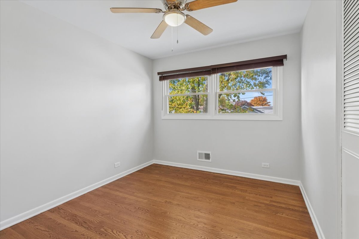 8846 North Ozanam Avenue Niles, IL 60714 - Photo 9 of 24 wooden floor in an empty room with a window