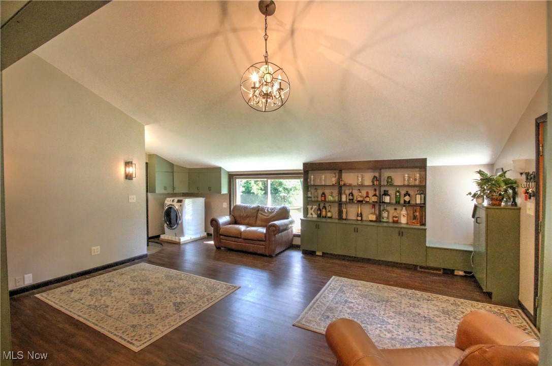 11375 Bean Road Chardon, OH 44024 - Photo 21 of 50 Living room with lofted ceiling, dark wood finished floors, a chandelier, and washer / clothes dryer