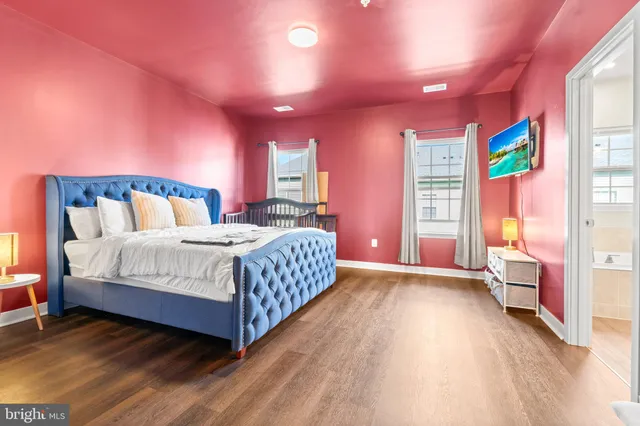 a bedroom with a bed and a dresser with mirror