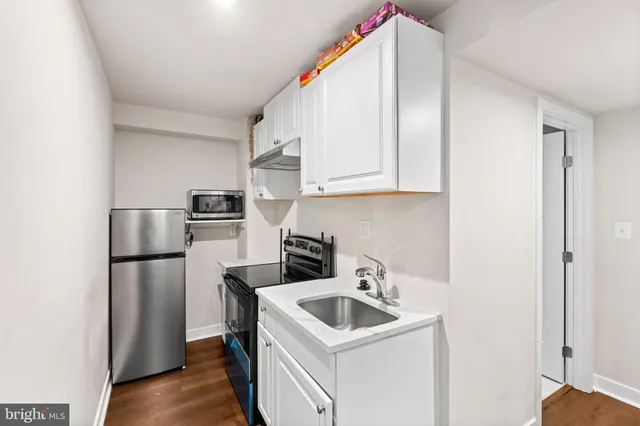 a kitchen with a sink a refrigerator and cabinets
