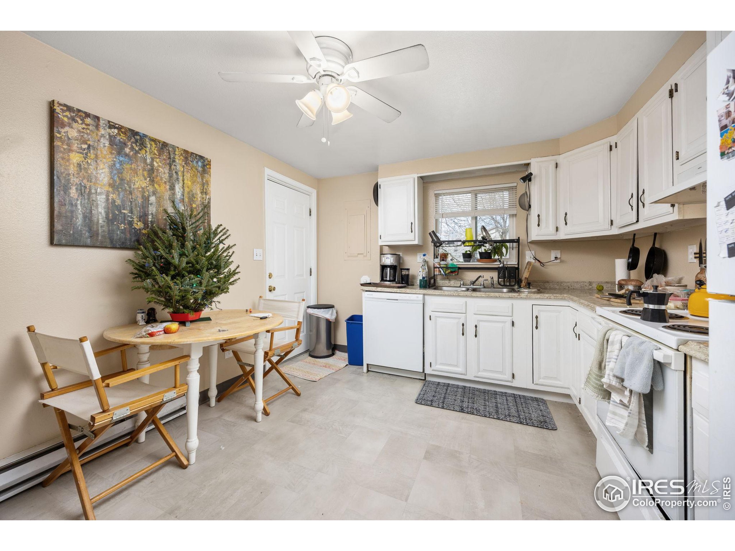 701 Aztec Drive Fort Collins, CO 80521 - Photo 17 of 43 a kitchen with a white cabinets and chairs in it
