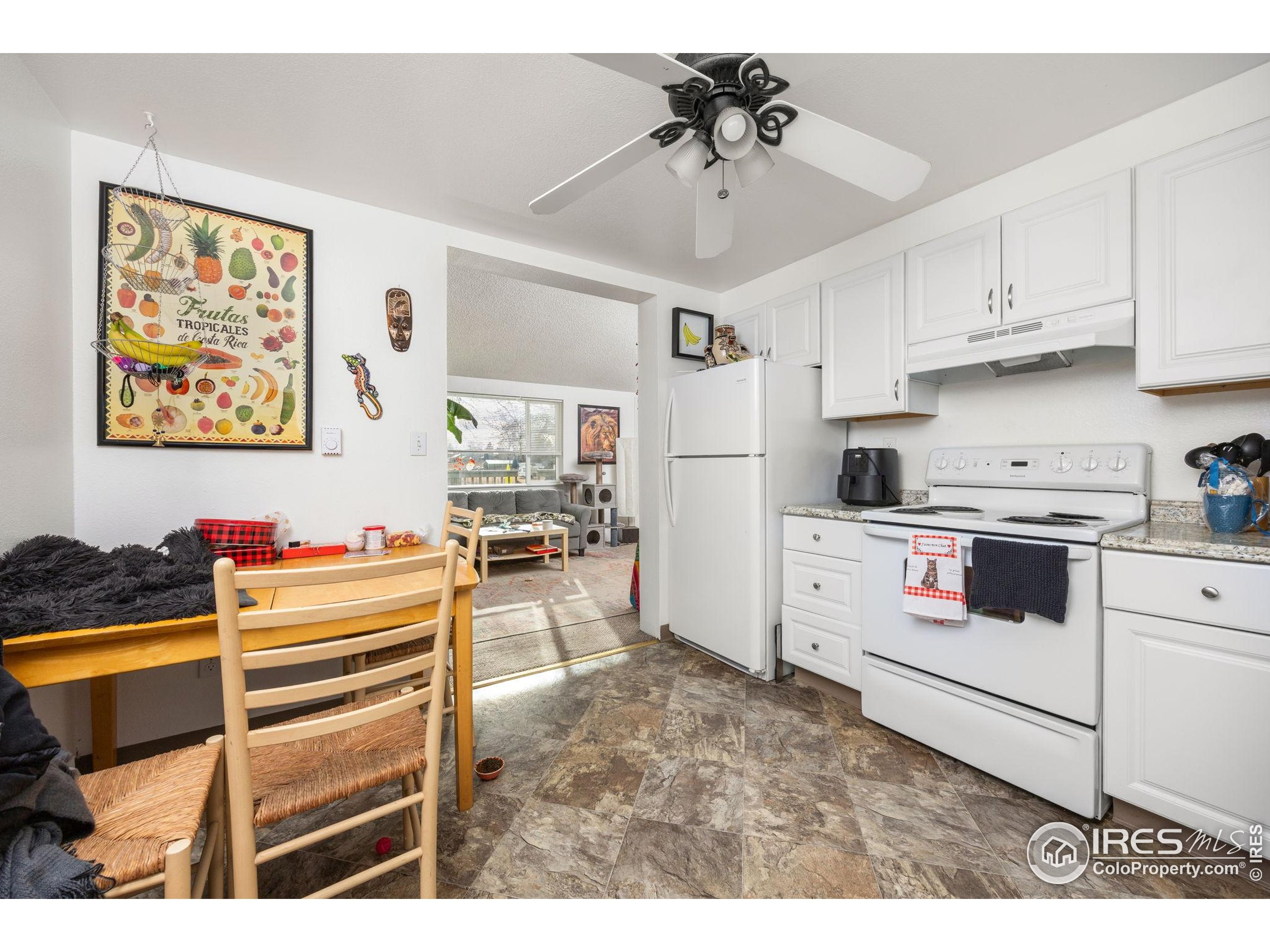 701 Aztec Drive Fort Collins, CO 80521 - Photo 8 of 43 a kitchen with stainless steel appliances kitchen island granite countertop a sink cabinets and black appliances