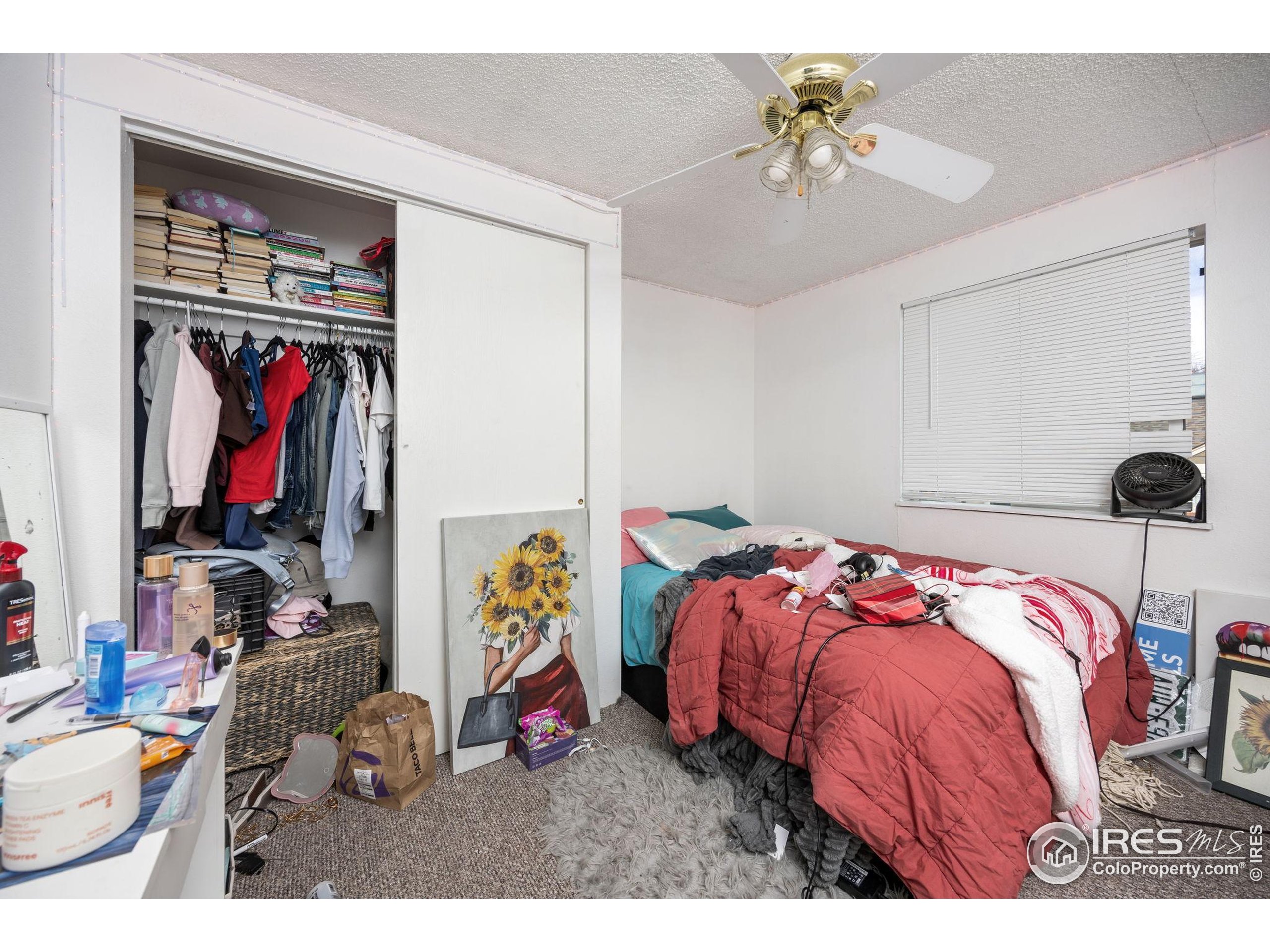 701 Aztec Drive Fort Collins, CO 80521 - Photo 10 of 43 a bedroom with a bed and a chandelier