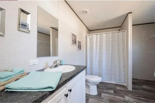 a bathroom with a granite countertop sink and a mirror