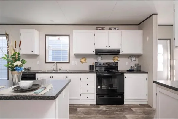 a kitchen with granite countertop a stove a sink and a granite counter tops