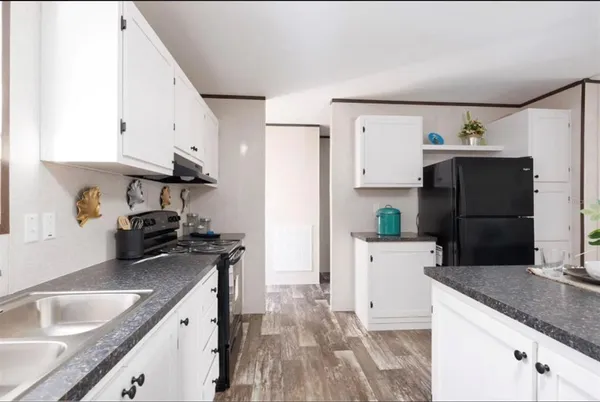 a kitchen with granite countertop a refrigerator stove and sink