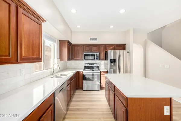 a kitchen with stainless steel appliances granite countertop a sink stove and refrigerator