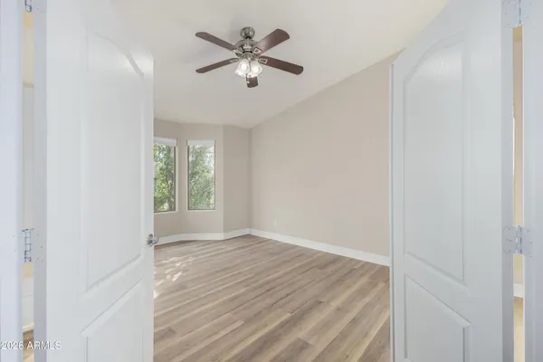 an empty room with wooden floor and windows