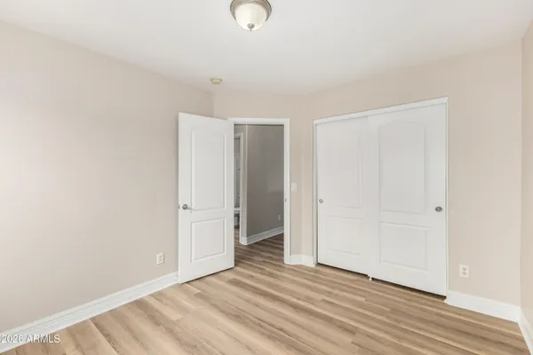 a view of empty room with window and wooden floor