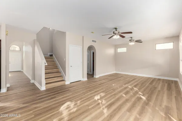a view of a room with wooden floor and ceiling fan