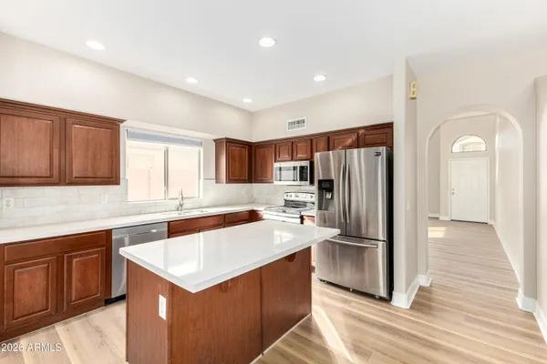 a kitchen with a sink a counter top space stainless steel appliances and cabinets