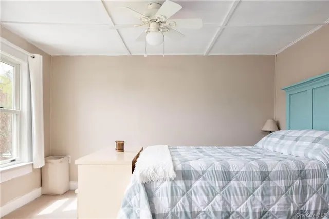 a bedroom with a white bed and a window