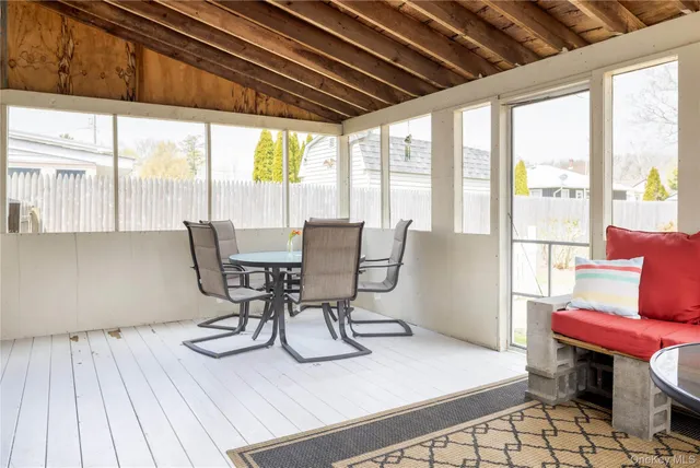 a dining room with furniture a rug and a large window