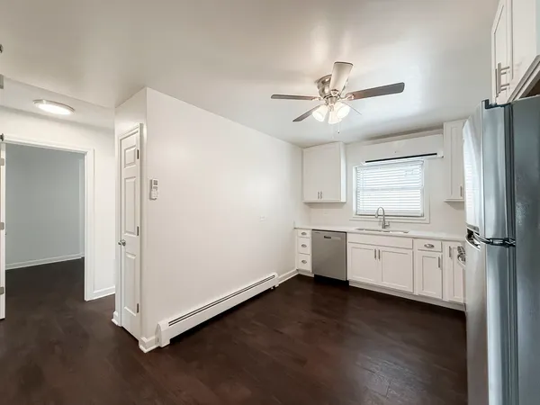 a kitchen with kitchen island white cabinets and wooden floor
