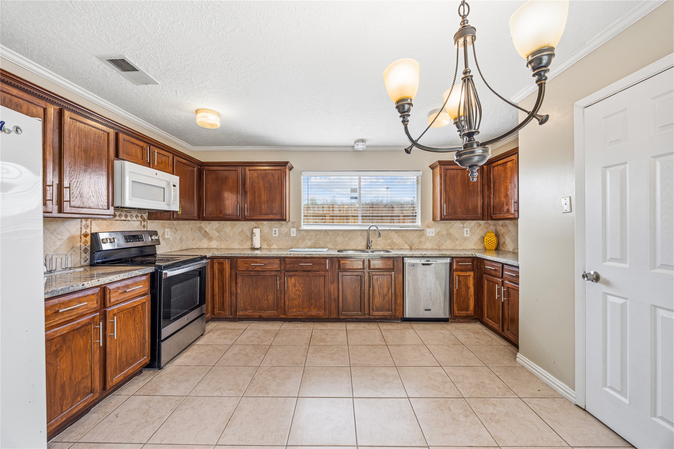 9206 Homeland Drive Houston, TX 77083 - Photo 18 of 39 a kitchen with stainless steel appliances granite countertop a stove a sink dishwasher and a refrigerator