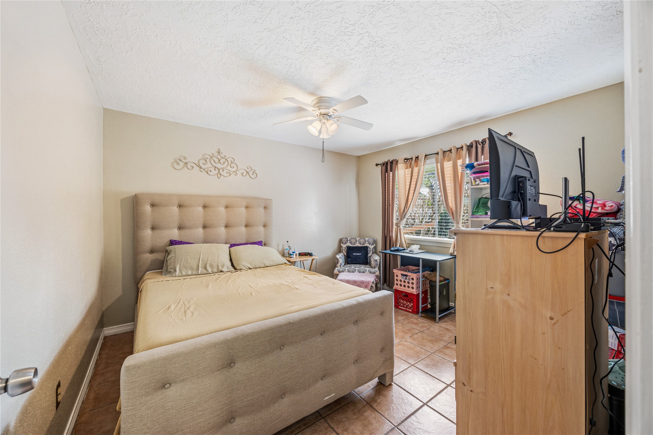 9206 Homeland Drive Houston, TX 77083 - Photo 22 of 39 a bedroom with a large bed a chandelier and dresser
