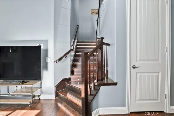 a view of a hallway with wooden floor and staircase