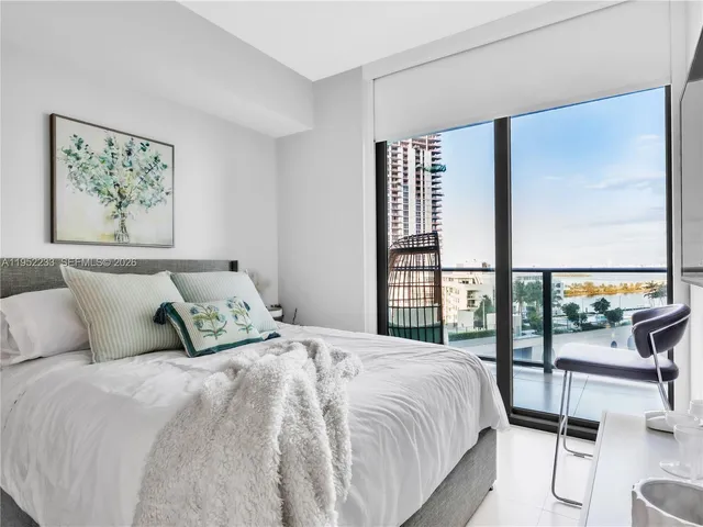 a bedroom with a large bed and a large window