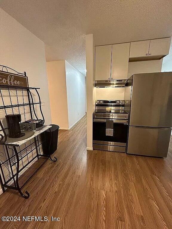104 Dickens Street Interlachen, FL 32148 - Photo 13 of 24 a kitchen with wooden floors and stainless steel appliances