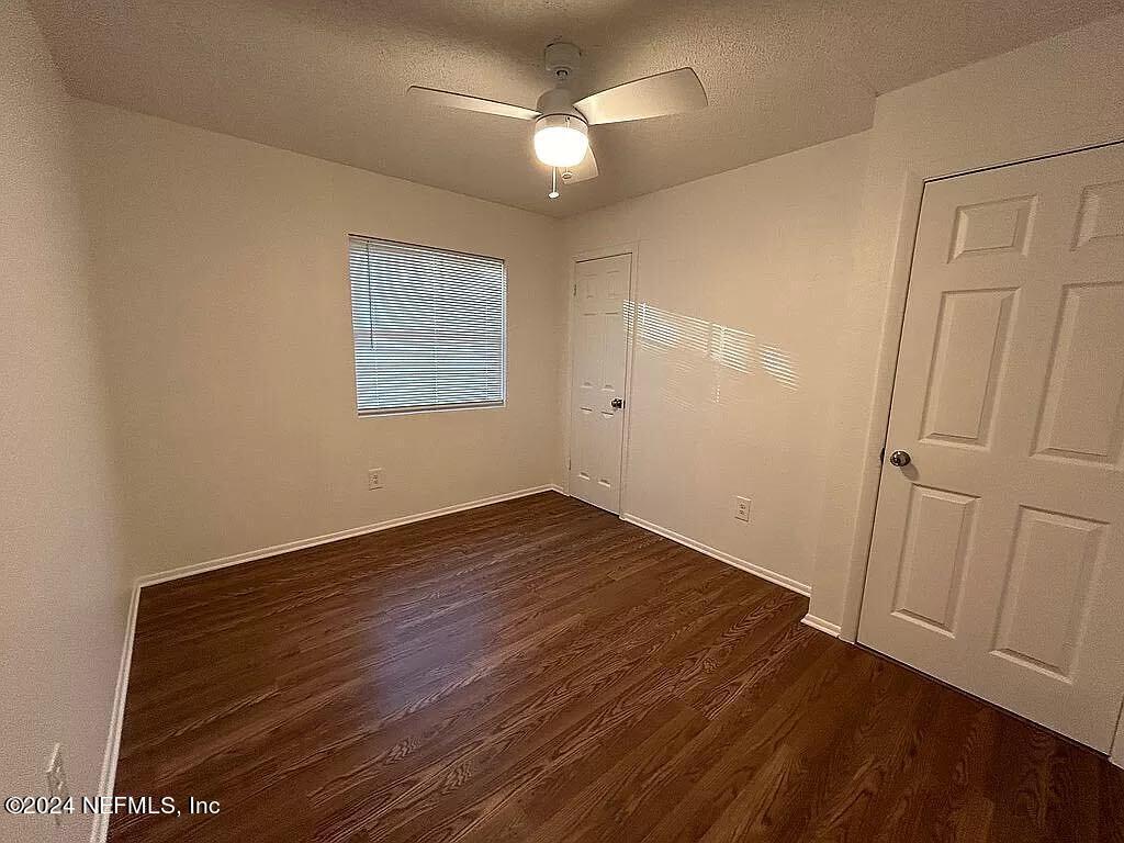 104 Dickens Street Interlachen, FL 32148 - Photo 22 of 24 an empty room with wooden floor and windows