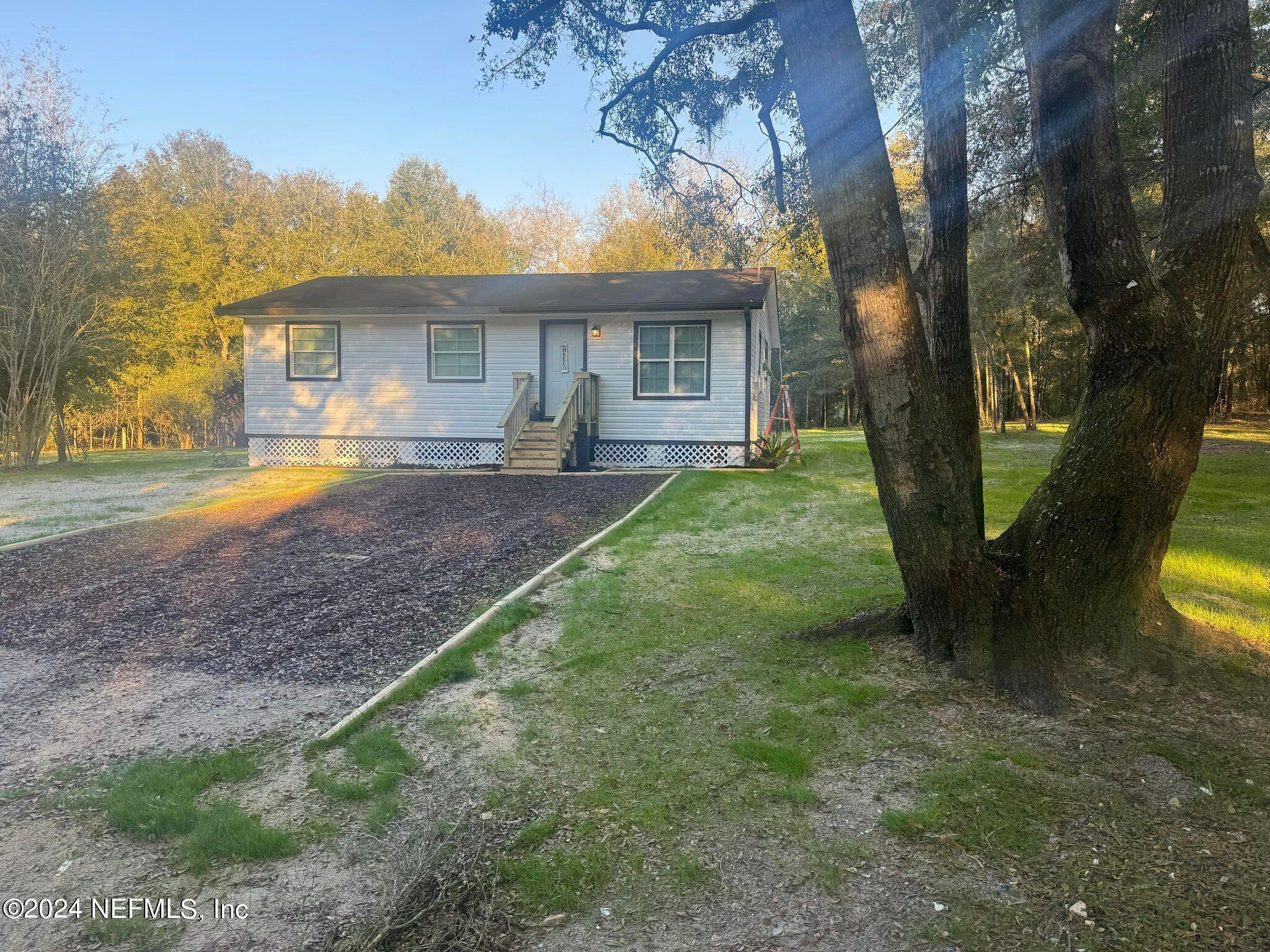 104 Dickens Street Interlachen, FL 32148 - Photo 5 of 24 a view of a house with backyard and a tree
