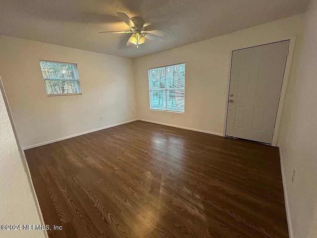104 Dickens Street Interlachen, FL 32148 - Photo 9 of 24 a view of an empty room with a window and wooden floor