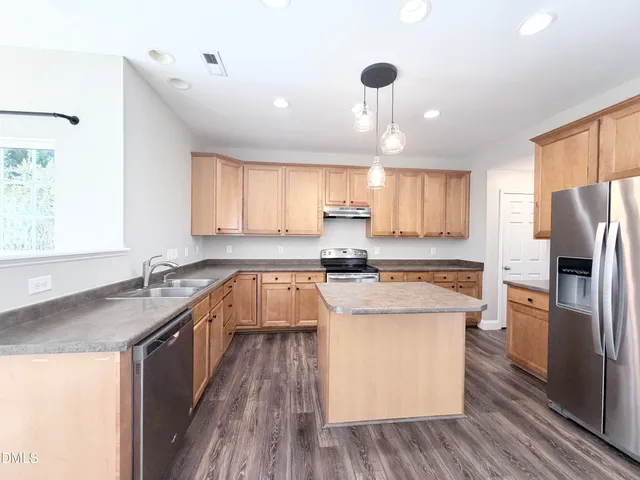 a kitchen with stainless steel appliances granite countertop a sink refrigerator and microwave