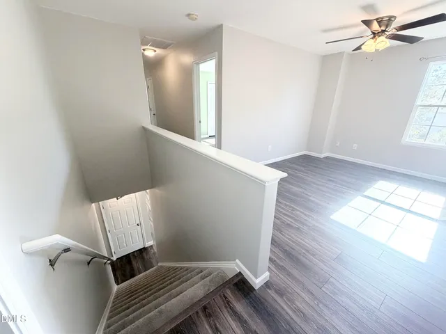 a view of a hallway with wooden floor and stairs