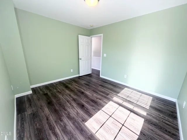 a view of a room with wooden floor and a carpet