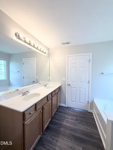 a spacious bathroom with a double vanity sink and mirror