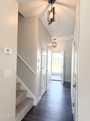 a view of hallway with stairs and wooden floor