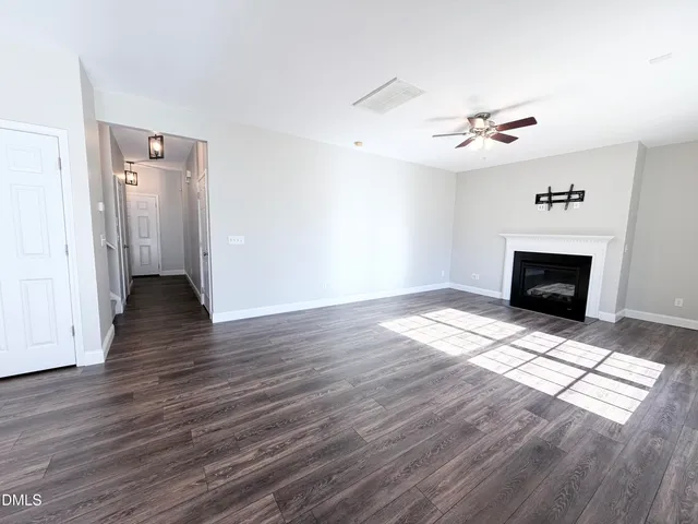 a view of empty room with wooden floor and fireplace