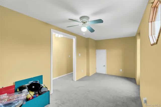 a view of empty room with a fan and a window