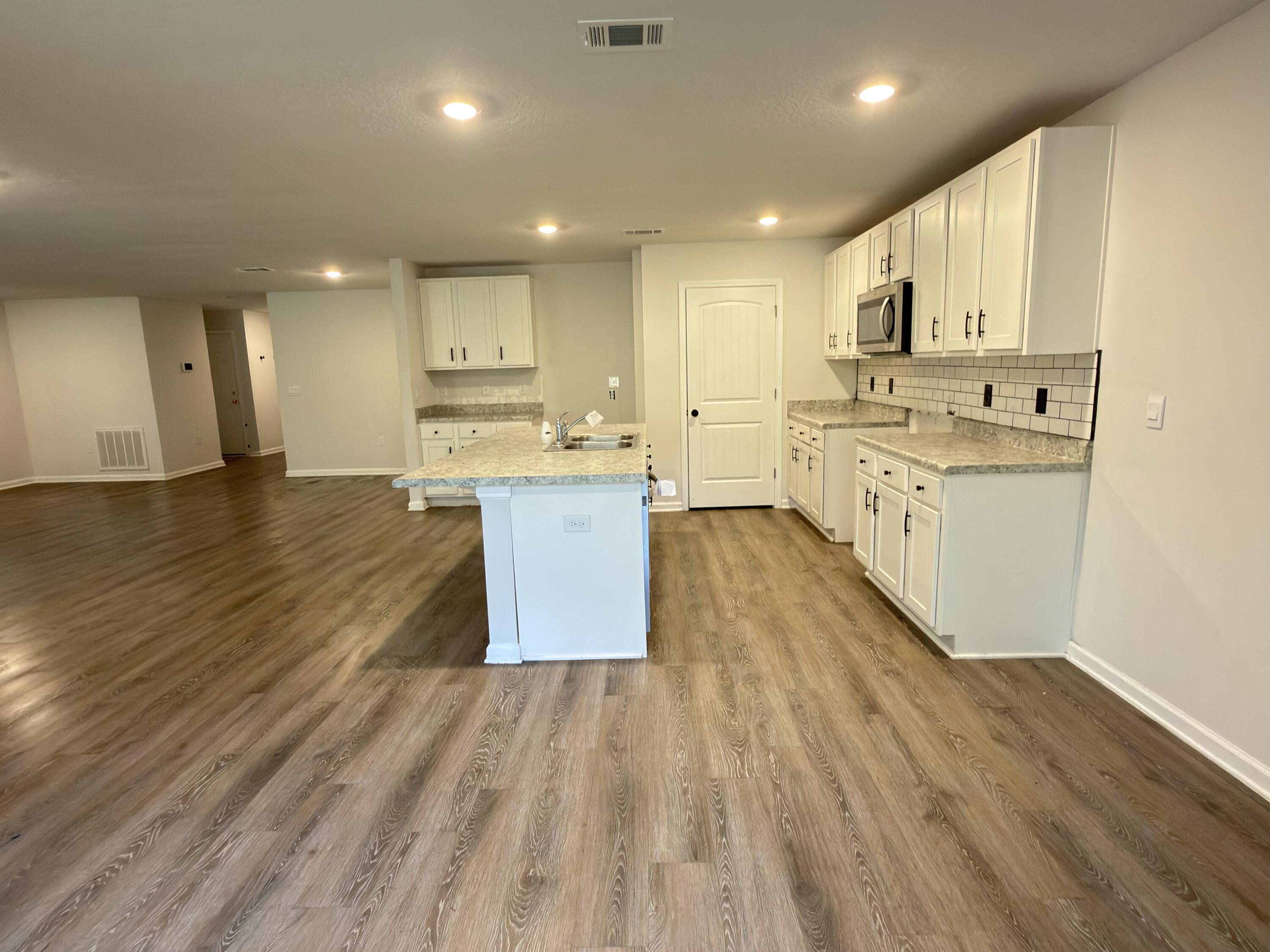 3545 Sugar Maple Lane Crestview, FL 32539 - Photo 6 of 27 a large kitchen with stainless steel appliances granite countertop a lot of counter space and wooden floors