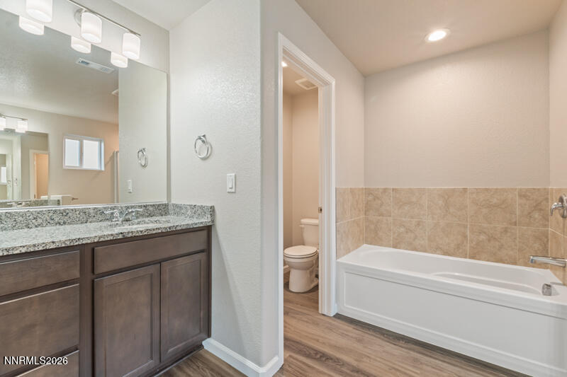 3622 Ruidoso Street Reno, NV 89512 - Photo 15 of 16 a bathroom with a granite countertop sink a toilet and bathtub