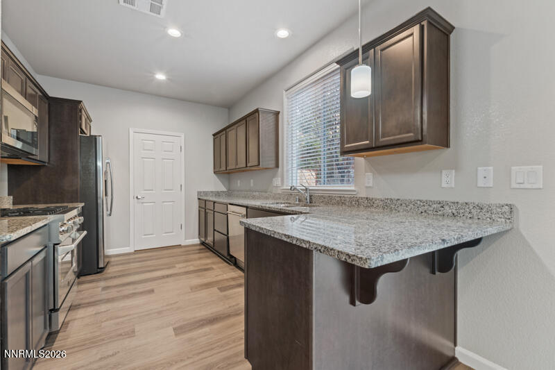 3622 Ruidoso Street Reno, NV 89512 - Photo 7 of 16 a kitchen with stainless steel appliances granite countertop a sink stove and refrigerator